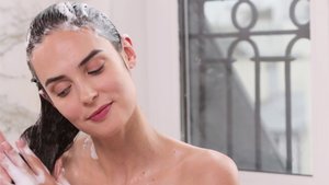 Mulher com o cabelo com espuma depois de usar um shampoo Kérastase