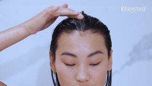 Mulher a aplicar produtos da gama symbiose no couro cabeludo