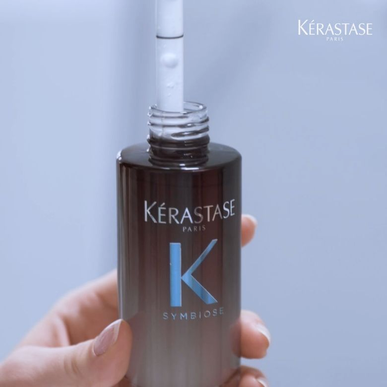 Mulher a retirar uma dose do Sérum da gama symbiose da kérastase